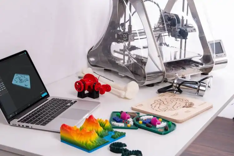 MacBook Pro beside 3D printer and printed items
