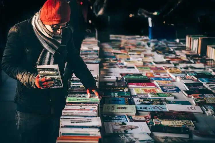 man picking up book ob book sale