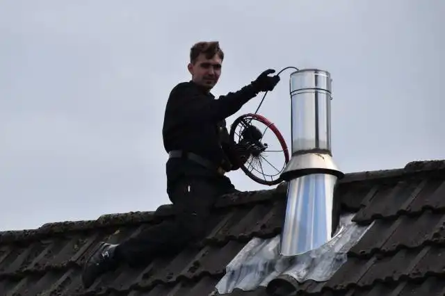 man in black jacket sitting on roof during daytime