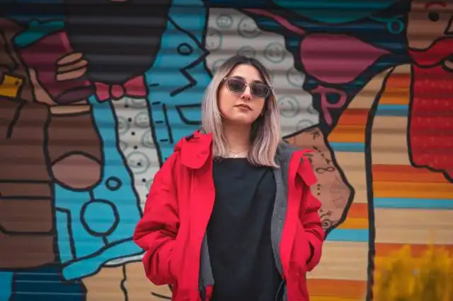 a woman standing in front of a colorful wall