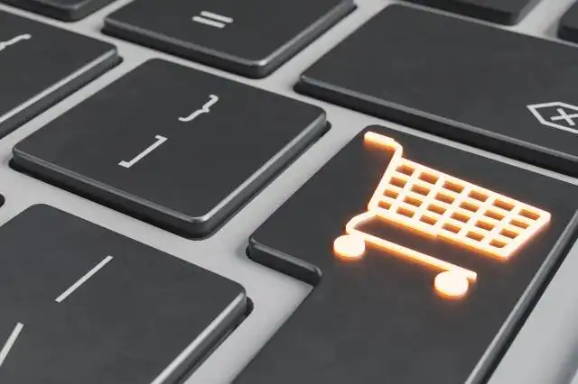 close up of a luminous shopping cart symbol on the enter key of a laptop. e-commerce concept, online business, dropshipping,