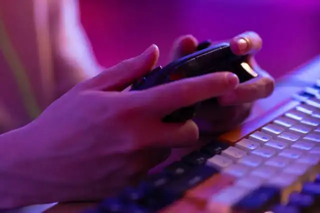a person typing on a keyboard with a cell phone
