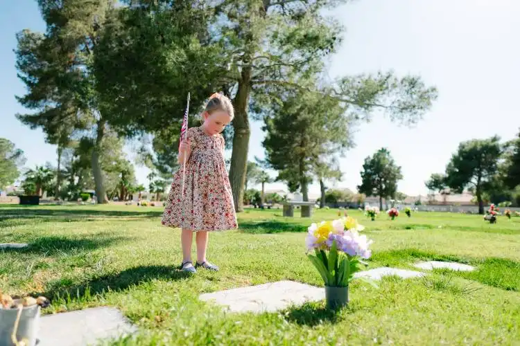 a little girl standing in the grass holding a baseball bat