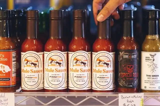 person holding brown glass bottles