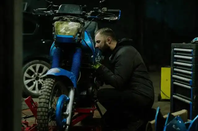 a man working on a motorcycle in a garage