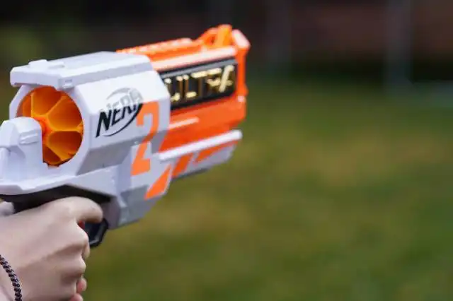 a close up of a person holding a toy gun