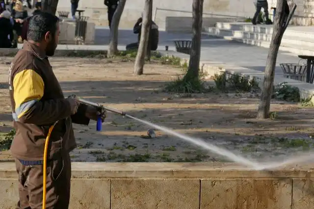 man in brown jacket holding black and gray stick