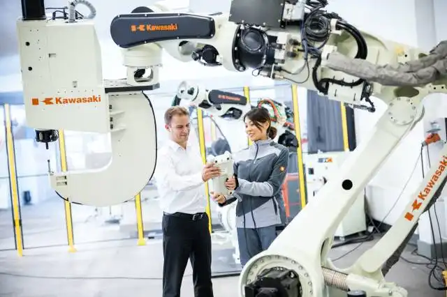 a man and a woman standing in front of a robot