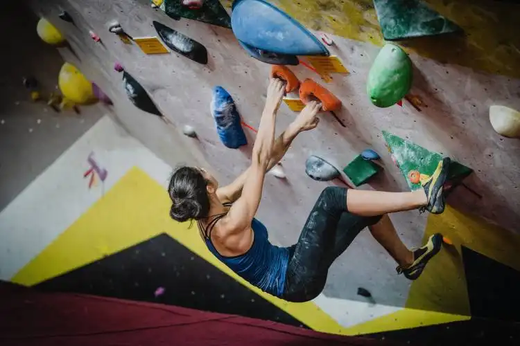 woman rock climbing inside building