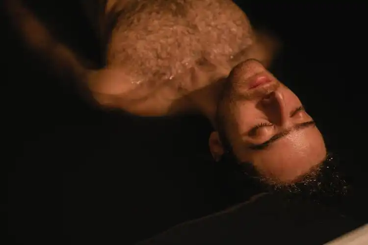 a man laying down with his eyes closed
