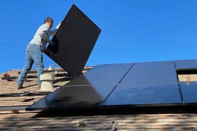 man in white dress shirt and blue denim jeans sitting on white and black solar panel