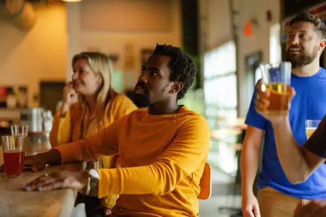 a group of people sitting at a bar with drinks