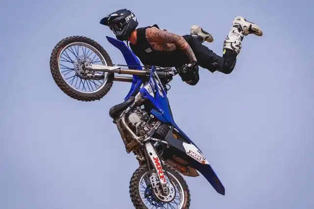 rider with blue dirt bike soaring on air