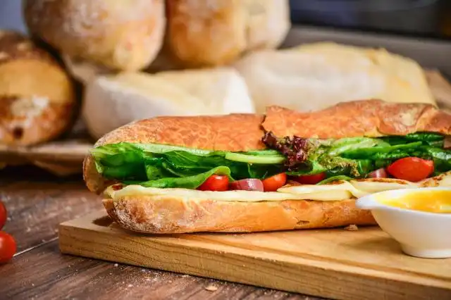 baked bread with vegetable on brown chopping board