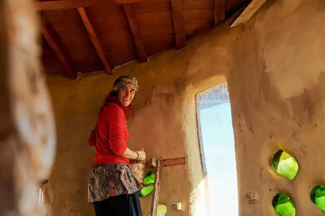 a woman in a red shirt is holding a skateboard