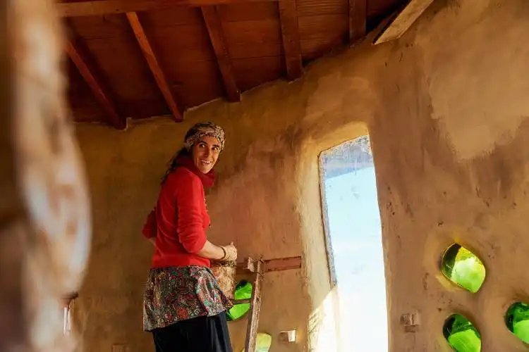 a woman in a red shirt is holding a skateboard