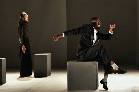 man in black suit sitting on gray chair