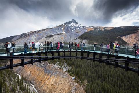 people standing on bridge near mountain during daytime