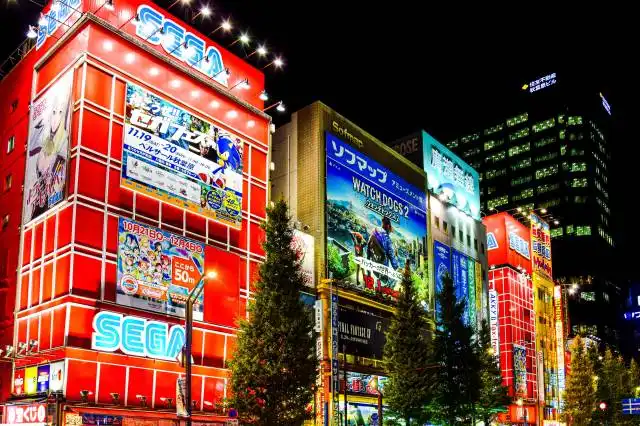 a city street at night with a lot of tall buildings