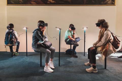 four person playing virtual reality goggles