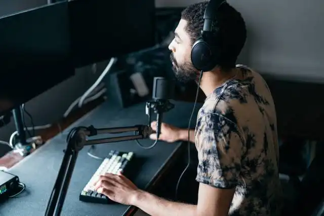 a man wearing headphones sitting in front of a microphone