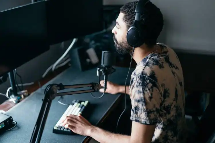 a man wearing headphones sitting in front of a microphone