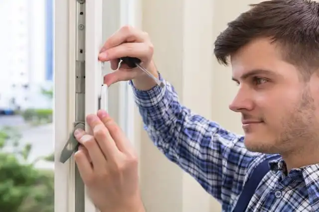 Close-up Of A Male Repairman Fixing Window With Screwdriver
