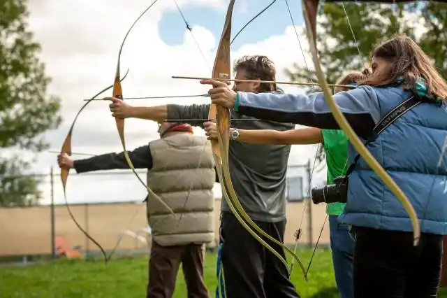 three person practicing using arrow