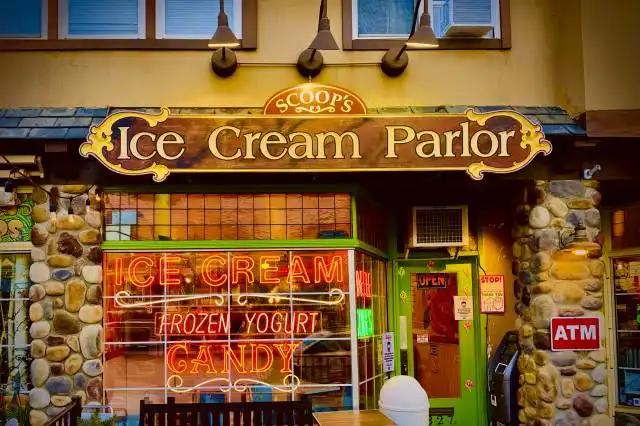 an ice cream parlor with a wooden bench in front of it