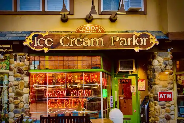 an ice cream parlor with a wooden bench in front of it