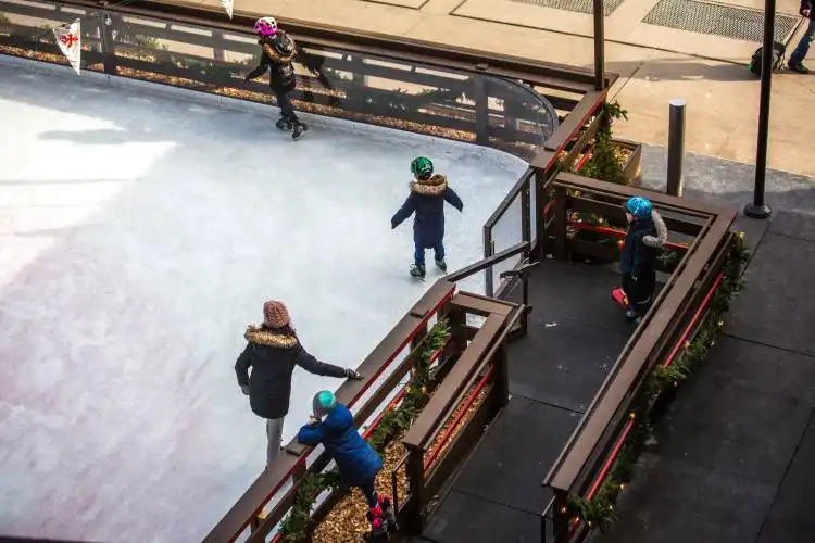 three children skating on ice rink