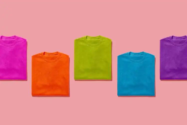 a group of five t - shirts on a pink background