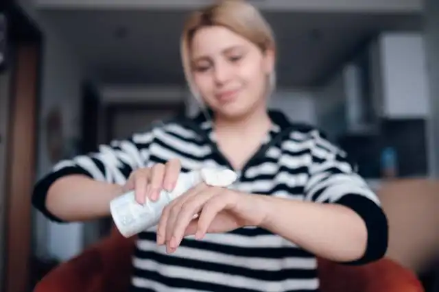 a woman in striped shirt holding a wii remote