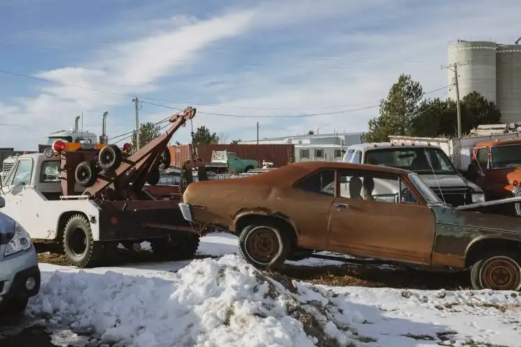 towing brown and white vintage car on snow covered